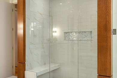 Example of a trendy white tile white floor walk-in shower design in Calgary with white walls and a hinged shower door