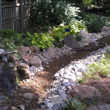 Shady Backyard with Waterfall, Stream, Fireplace and Landscape