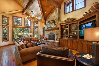 Expansive open concept family room in Salt Lake City with medium hardwood floors, a standard fireplace, a stone fireplace surround, a built-in media wall and yellow walls.