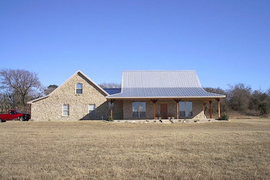 Modelo de fachada de casa multicolor tradicional de tamaño medio de una planta con revestimiento de piedra, tejado a dos aguas y tejado de metal