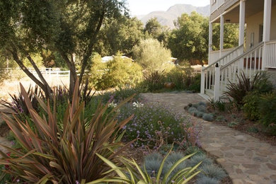 Inspiration for a large farmhouse shade backyard stone landscaping in Los Angeles.