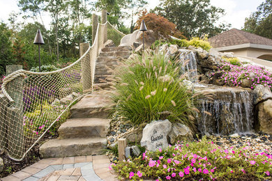 Example of a large beach style backyard concrete paver patio fountain design in New York with a gazebo
