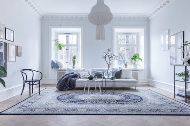 This is an example of a large traditional formal enclosed living room in Gothenburg with white walls, light hardwood floors, no tv and beige floor.