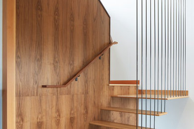 Inspiration for a small contemporary wood floating staircase in Portland with open risers and metal railing.