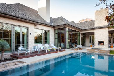 Immagine di una grande piscina a sfioro infinito classica rettangolare dietro casa con una vasca idromassaggio e pavimentazioni in pietra naturale