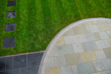 This is an example of a contemporary patio in Other with natural stone paving.