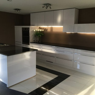 This is an example of a mid-sized contemporary l-shaped kitchen pantry in Christchurch with an undermount sink, white cabinets, granite benchtops, brown splashback, stainless steel appliances, porcelain floors, with island and yellow floor.