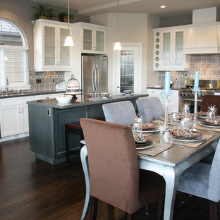 Mid-sized traditional kitchen pantry ideas - Kitchen pantry - mid-sized traditional l-shaped dark wood floor kitchen pantry idea in Wilmington with white cabinets, granite countertops, an undermount sink, glass-front cabinets, gray backsplash, ceramic backsplash, stainless steel appliances and an island