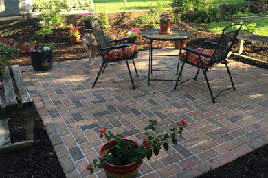 Photo of a mid-sized traditional backyard patio in Minneapolis with brick pavers and no cover.