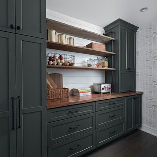 На фото: линейные кухни в стиле современная классика с кладовкой, фасадами в стиле шейкер, деревянной столешницей, белым фартуком, темным паркетным полом, коричневым полом и коричневой столешницей