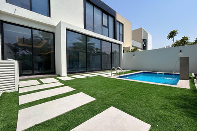 Pool - mid-sized modern backyard pool idea in Other
