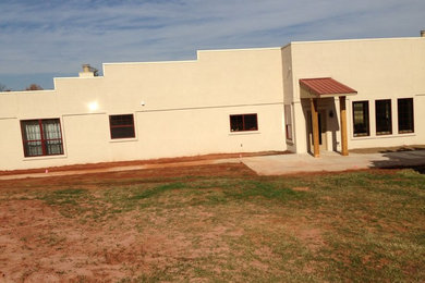 Inspiration for a large southwestern beige one-story concrete exterior home remodel in Oklahoma City with a tile roof