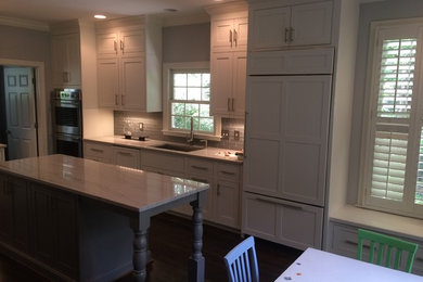 Eat-in kitchen - mid-sized craftsman dark wood floor eat-in kitchen idea in Birmingham with an undermount sink, shaker cabinets, white cabinets, marble countertops, gray backsplash, glass tile backsplash, stainless steel appliances and an island