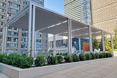Inspiration for a modern mixed material railing balcony remodel in Toronto with a pergola