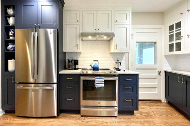 Enclosed kitchen - small traditional u-shaped medium tone wood floor and brown floor enclosed kitchen idea in Oklahoma City with a single-bowl sink, shaker cabinets, brown cabinets, quartz countertops, white backsplash, subway tile backsplash, stainless steel appliances, no island and white countertops
