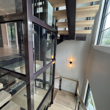 Project #136 | Modern Floating Staircase Encircling Glass Elevator