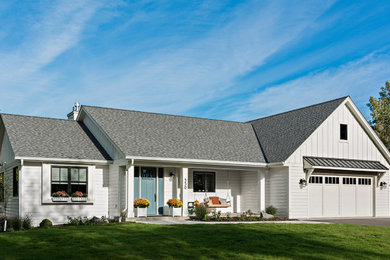 Mid-sized farmhouse white two-story wood and board and batten house exterior photo in Minneapolis with a shingle roof and a brown roof