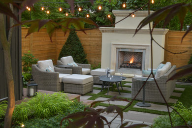 Ejemplo de jardín minimalista de tamaño medio en verano en patio trasero con jardín francés, chimenea, exposición reducida al sol, adoquines de piedra natural y con madera