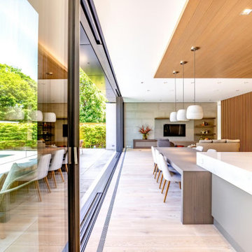 Open concept kitchen and dining space with NanaWall minimal sliding glass walls