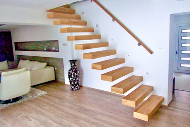 Exemple d'un escalier sans contremarche flottant tendance de taille moyenne avec des marches en bois et un garde-corps en bois.