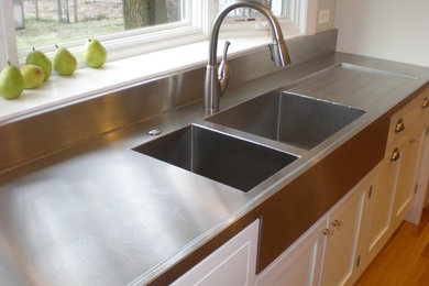 Kitchen - kitchen idea in Chicago with a double-bowl sink, stainless steel countertops and stainless steel appliances