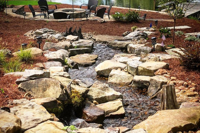 Klassischer Garten hinter dem Haus mit Feuerstelle und Natursteinplatten in Birmingham