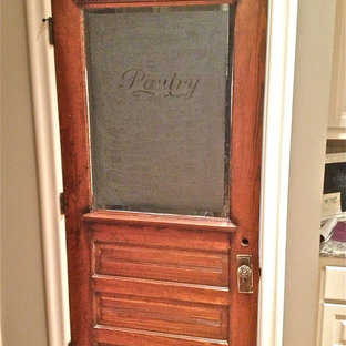 Rustic kitchen pantry photos - Kitchen pantry - rustic medium tone wood floor kitchen pantry idea in Jackson with a farmhouse sink, raised-panel cabinets, white cabinets, granite countertops, beige backsplash, stone tile backsplash, stainless steel appliances and an island