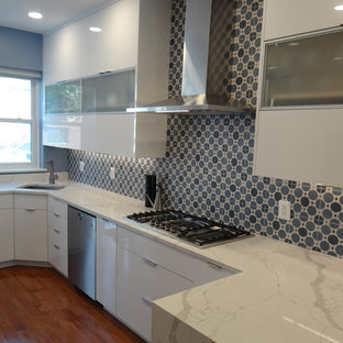 Выдающиеся фото от архитекторов и дизайнеров интерьера: маленькая отдельная, параллельная кухня в стиле модернизм с врезной раковиной, плоскими фасадами, белыми фасадами, столешницей из кварцевого композита, синим фартуком, фартуком из цементной плитки, техникой из нержавеющей стали, паркетным полом среднего тона, полуостровом, оранжевым полом и белой столешницей