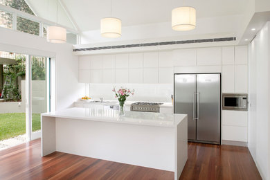 This is an example of a kitchen in Sydney with white cabinets.