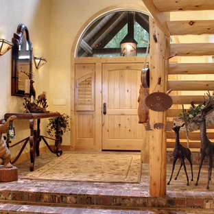 Eklektisk inredning av en mellanstor foajé, med beige väggar, tegelgolv, en enkeldörr och ljus trädörr