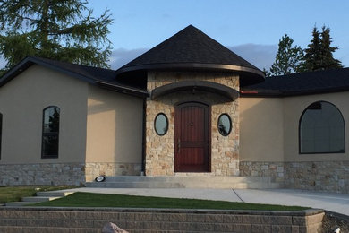 Example of a mid-sized beige one-story stucco exterior home design in Calgary