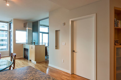 Example of a mid-sized trendy open concept medium tone wood floor living room design in Seattle with beige walls and a hanging fireplace
