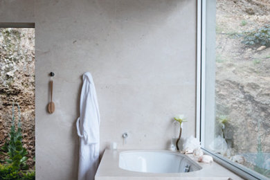 Diseño de cuarto de baño principal contemporáneo de tamaño medio con bañera esquinera, suelo de piedra caliza y encimera de piedra caliza