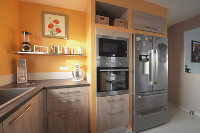 Réalisation d'une cuisine ouverte design en U et bois clair de taille moyenne avec un évier posé, un placard à porte plane, un plan de travail en quartz, une crédence grise, un électroménager en acier inoxydable, un sol en carrelage de céramique, îlot et un sol gris.