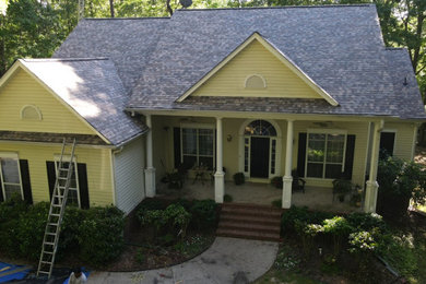 Imagen de fachada de casa beige y marrón de tamaño medio de dos plantas con revestimiento de madera y tejado de teja de madera