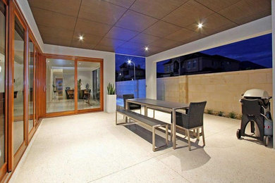 Inspiration for a mid-sized contemporary side yard patio in Perth with a roof extension.
