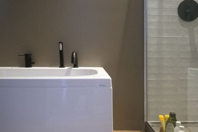 Immagine di una stanza da bagno con doccia con ante in legno chiaro, vasca idromassaggio, doccia a filo pavimento, WC a due pezzi, piastrelle marroni, piastrelle in ceramica, pareti marroni, pavimento con piastrelle in ceramica, lavabo a bacinella, pavimento marrone, un lavabo e mobile bagno sospeso