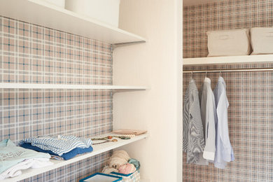 This is an example of a mid-sized country gender-neutral walk-in wardrobe in Other with white cabinets.