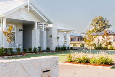 Design ideas for a large traditional full sun front yard brick and metal fence landscaping in Newcastle - Maitland for spring.
