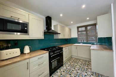 Design ideas for a medium sized u-shaped enclosed kitchen in Other with a single-bowl sink, shaker cabinets, green cabinets, wood worktops, green splashback, ceramic splashback and multi-coloured floors.