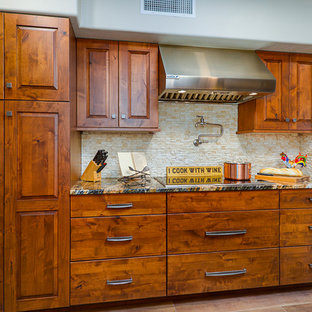 Große Urige Küche in U-Form mit Vorratsschrank, flächenbündigen Schrankfronten, Schränken im Used-Look, Mineralwerkstoff-Arbeitsplatte, Küchenrückwand in Beige, Rückwand aus Travertin, Küchengeräten aus Edelstahl, Porzellan-Bodenfliesen, Kücheninsel, braunem Boden, schwarzer Arbeitsplatte und integriertem Waschbecken in Phoenix