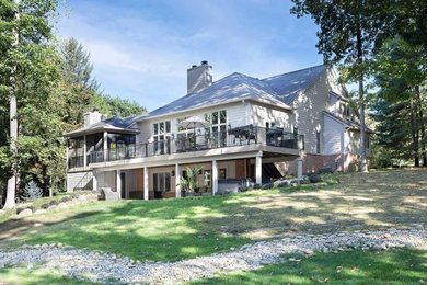 Inspiration for a large transitional beige two-story clapboard house exterior remodel in Detroit with a shingle roof and a gray roof