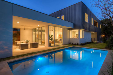 Inspiration for a mid-sized contemporary backyard concrete and rectangular lap pool house remodel in Austin
