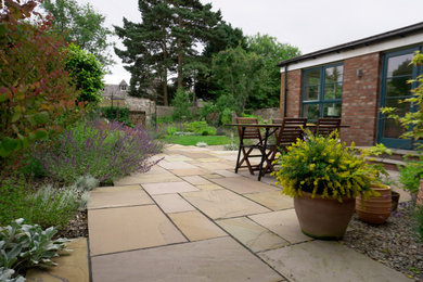 Design ideas for a medium sized contemporary back patio in Other with a fireplace, natural stone paving and no cover.