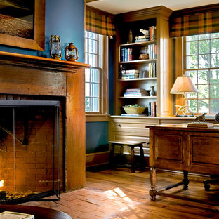 Idéer för ett klassiskt arbetsrum, med blå väggar, mellanmörkt trägolv, en spiselkrans i tegelsten, en standard öppen spis och brunt golv