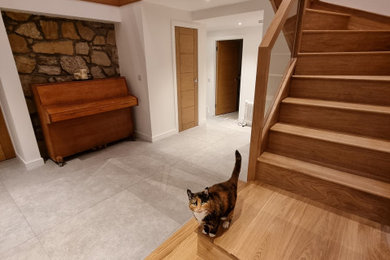 Inspiration for a medium sized rustic wood l-shaped glass railing staircase in Edinburgh with wood risers and a feature wall.