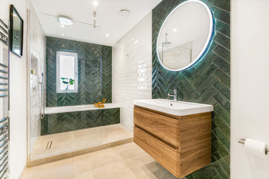 Small contemporary family bathroom in London with flat-panel cabinets, medium wood cabinets, a built-in bath, a walk-in shower, a one-piece toilet, green tiles, ceramic tiles, white walls, ceramic flooring, a built-in sink, beige floors, an open shower, white worktops, a wall niche, a single sink and a floating vanity unit.