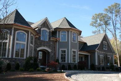 Example of a large classic green two-story concrete fiberboard exterior home design in New York
