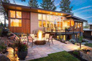 Inspiration for a mid-sized contemporary backyard concrete paver patio remodel in Portland with a fire pit and a roof extension