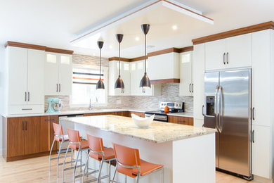 Eat-in kitchen - mid-sized transitional l-shaped light wood floor eat-in kitchen idea in Other with an undermount sink, flat-panel cabinets, white cabinets, granite countertops, multicolored backsplash, mosaic tile backsplash, stainless steel appliances and an island